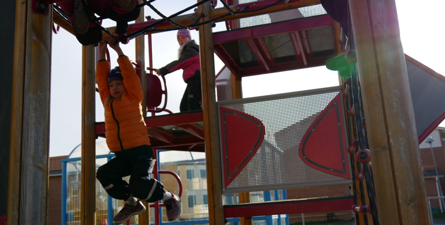 Ett barn hänger i en lekställning.